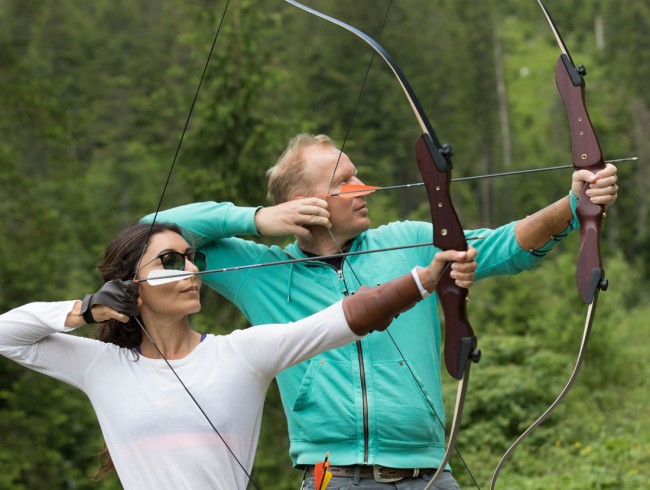 Paar beim Bogenschießen im Wald