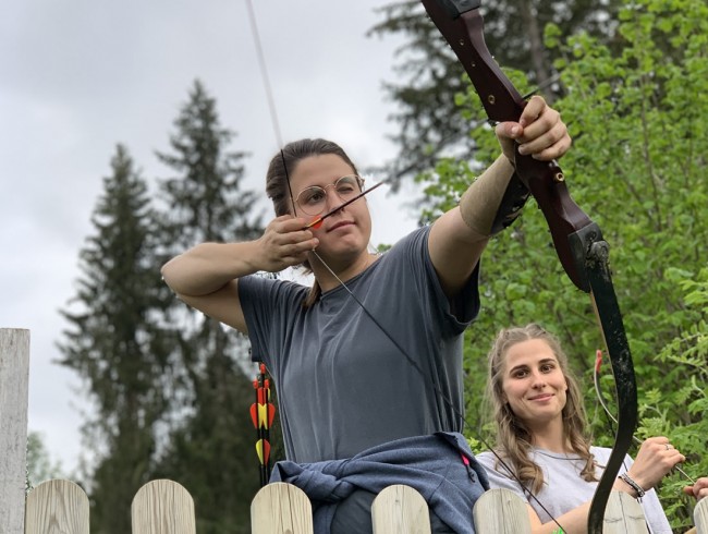 Damen beim Bogenschießen im Wald